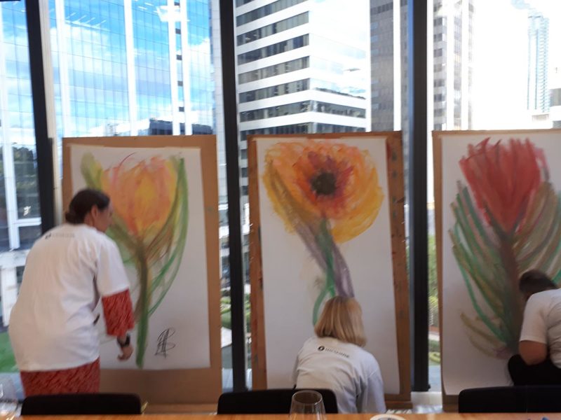 Three people drawing flowers