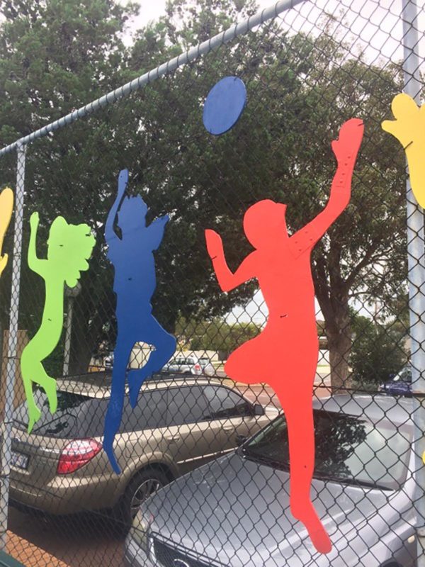 Fence with colourful athlete silhouettes attached