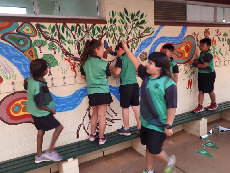 Children working on painting feature wall