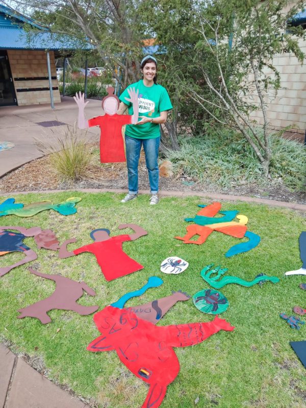 Woman in green standing with a piece of artwork
