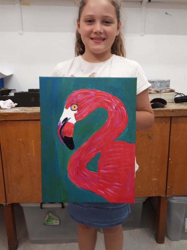 Child holding a painting of flamingo
