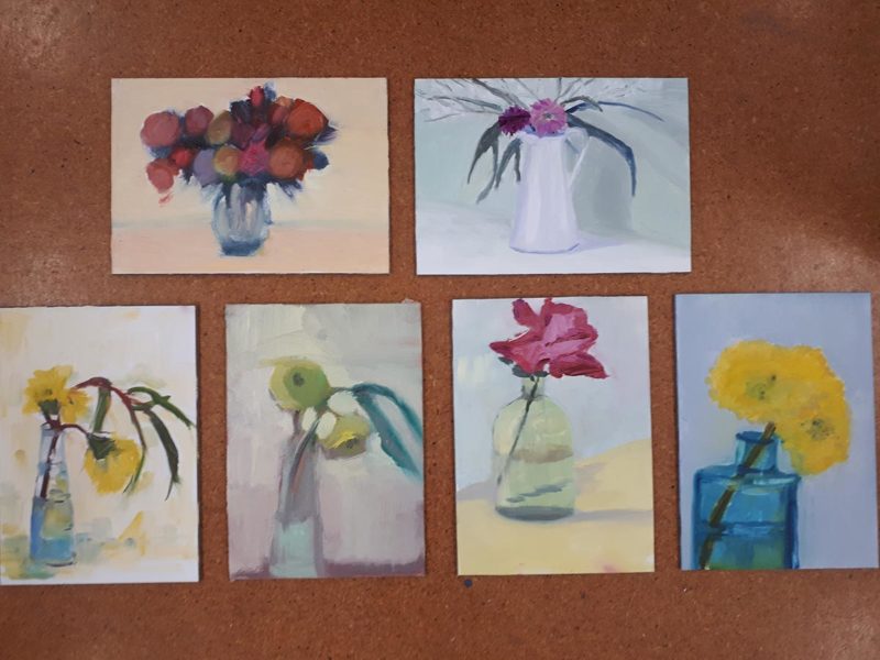 Set of paintings of flowers in vases on a brown board