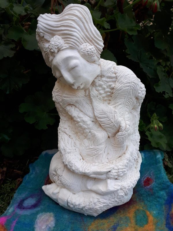 Clay sculptures of character in front of greenery