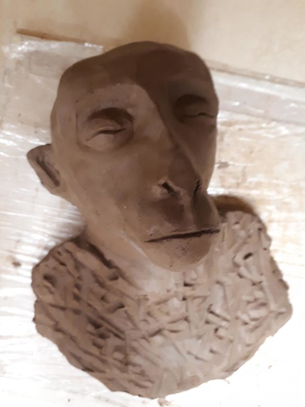 Brown clay sculpture of a character's head