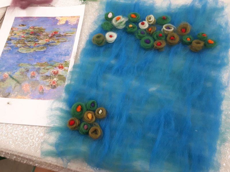 Felting water-lilies onto blue background
