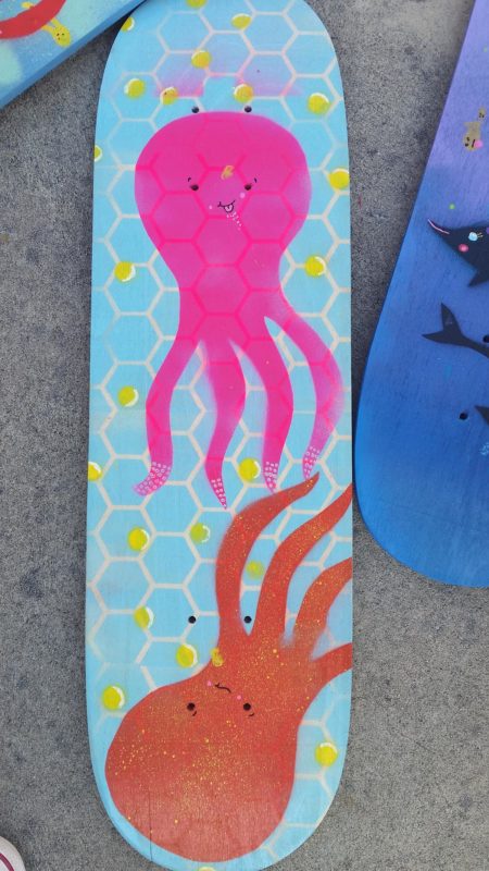 Painting on a skateboard deck of octopi